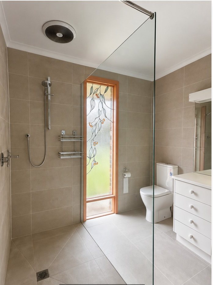 The same bathroom after renovation by Simply Handy, fully retiled with a frameless shower